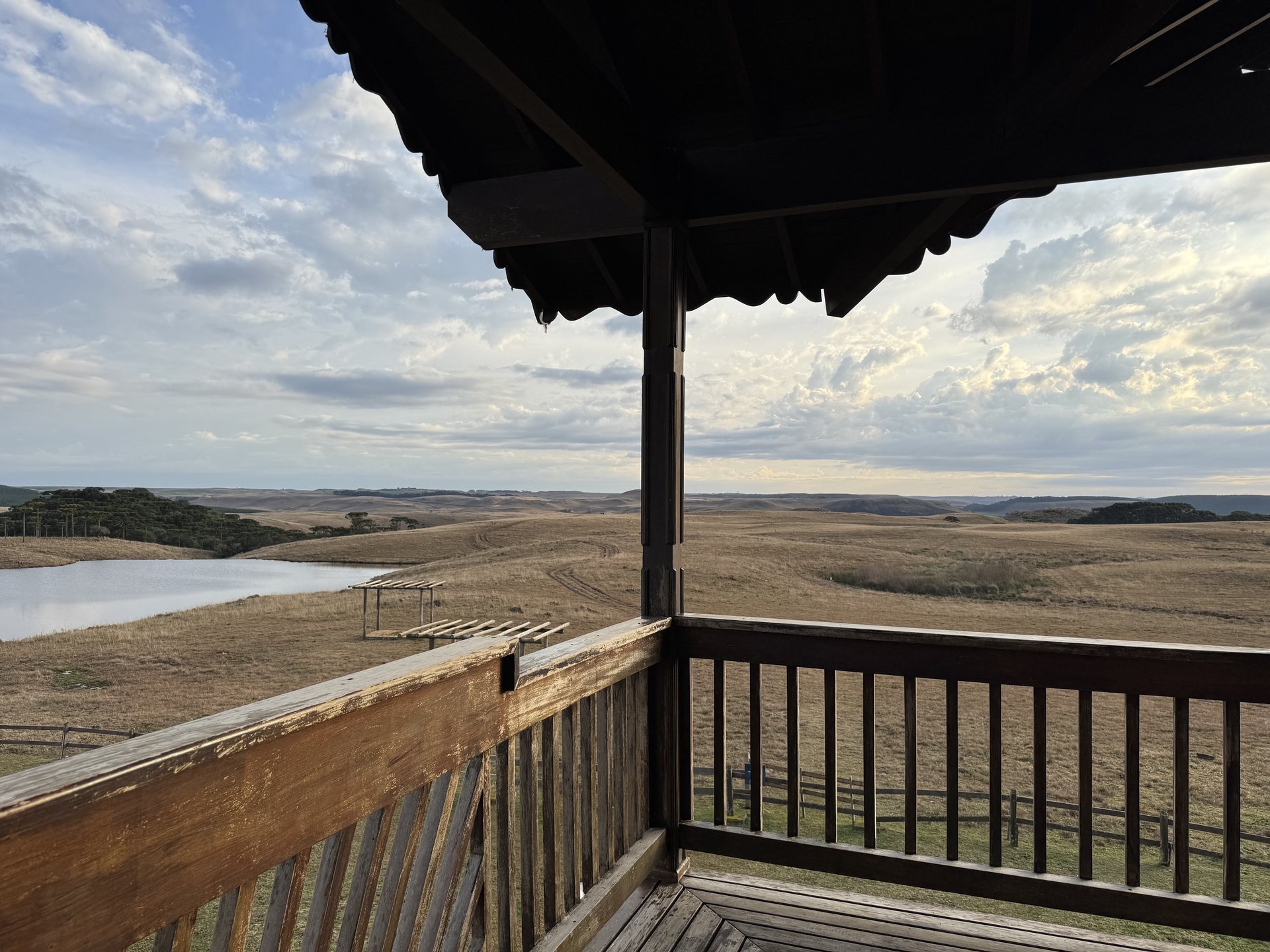Varanda da suíte com vista para o lago e os campos ao entardecer
